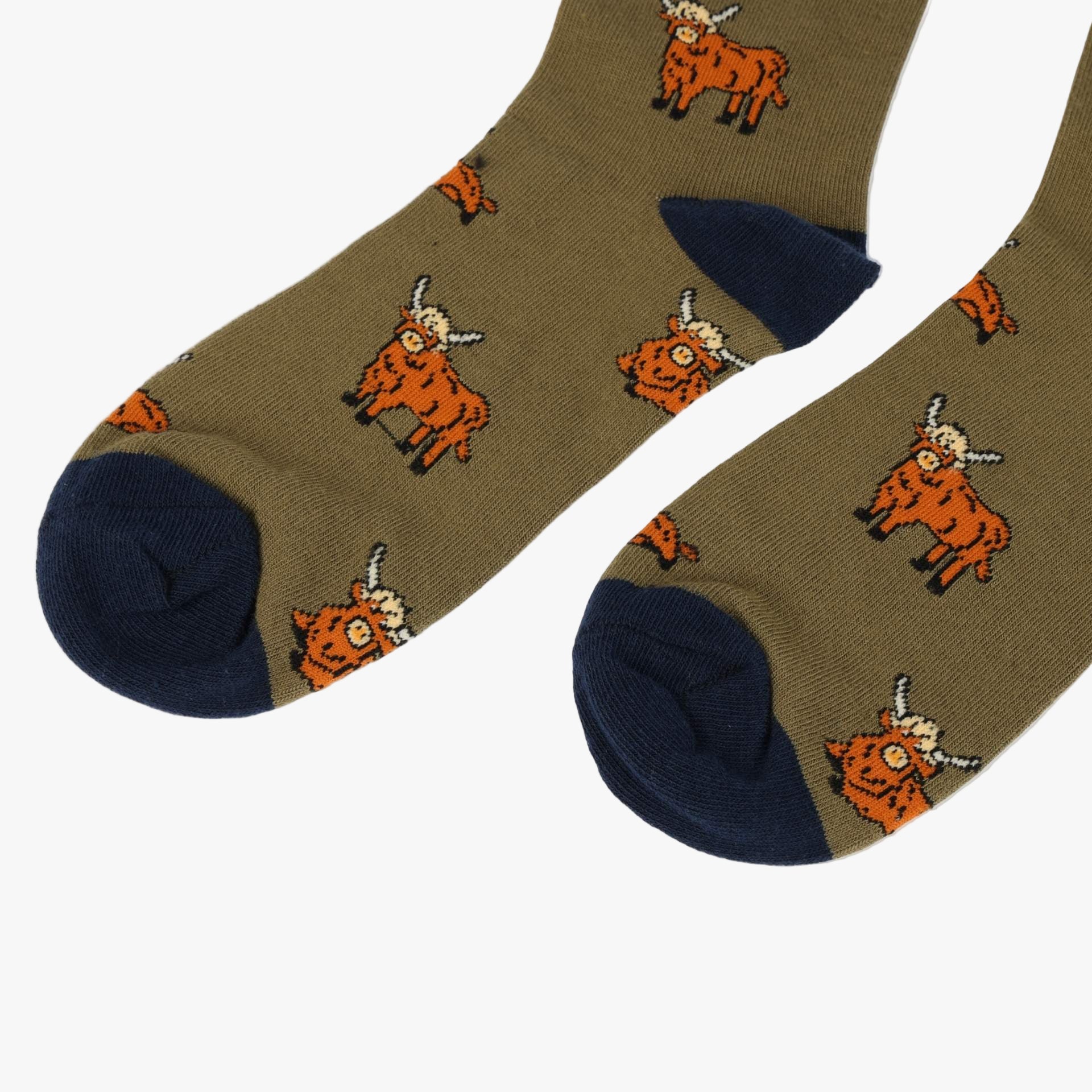 Pair of socks with orange cow pattern on a beige background