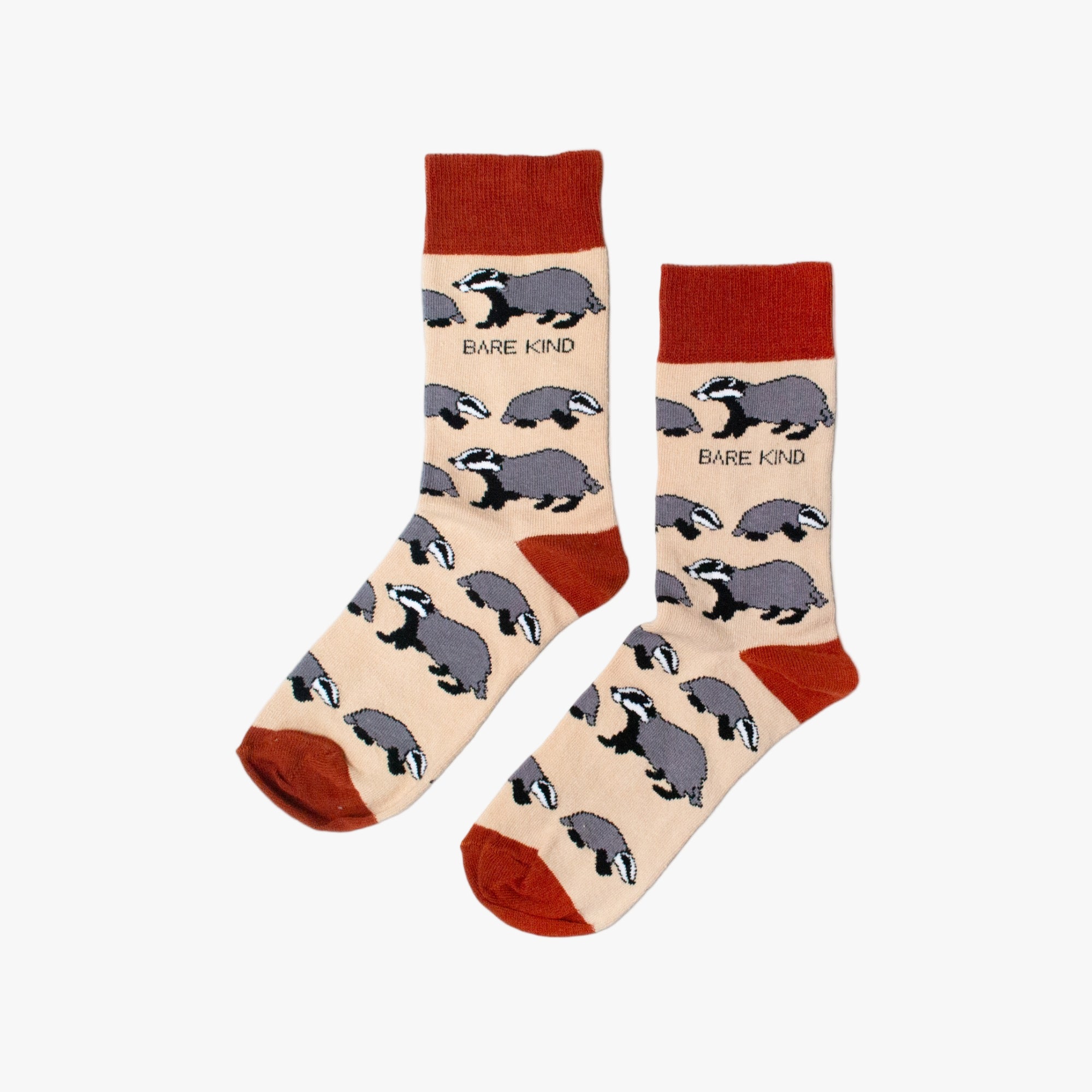 Pair of socks with badger pattern and 'Bare Kind' text on a beige background