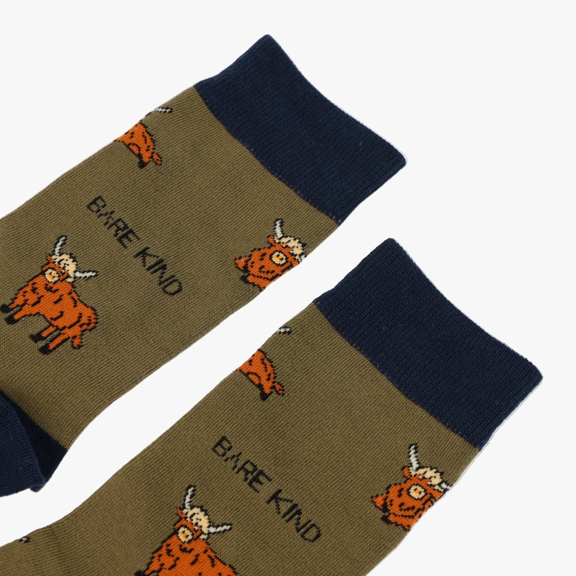 Pair of socks with cartoon cow design and 'Bare Kind' text on a white background