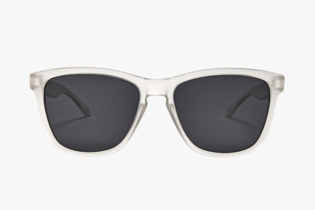 Sunglasses with clear frame and dark lenses on a white background
