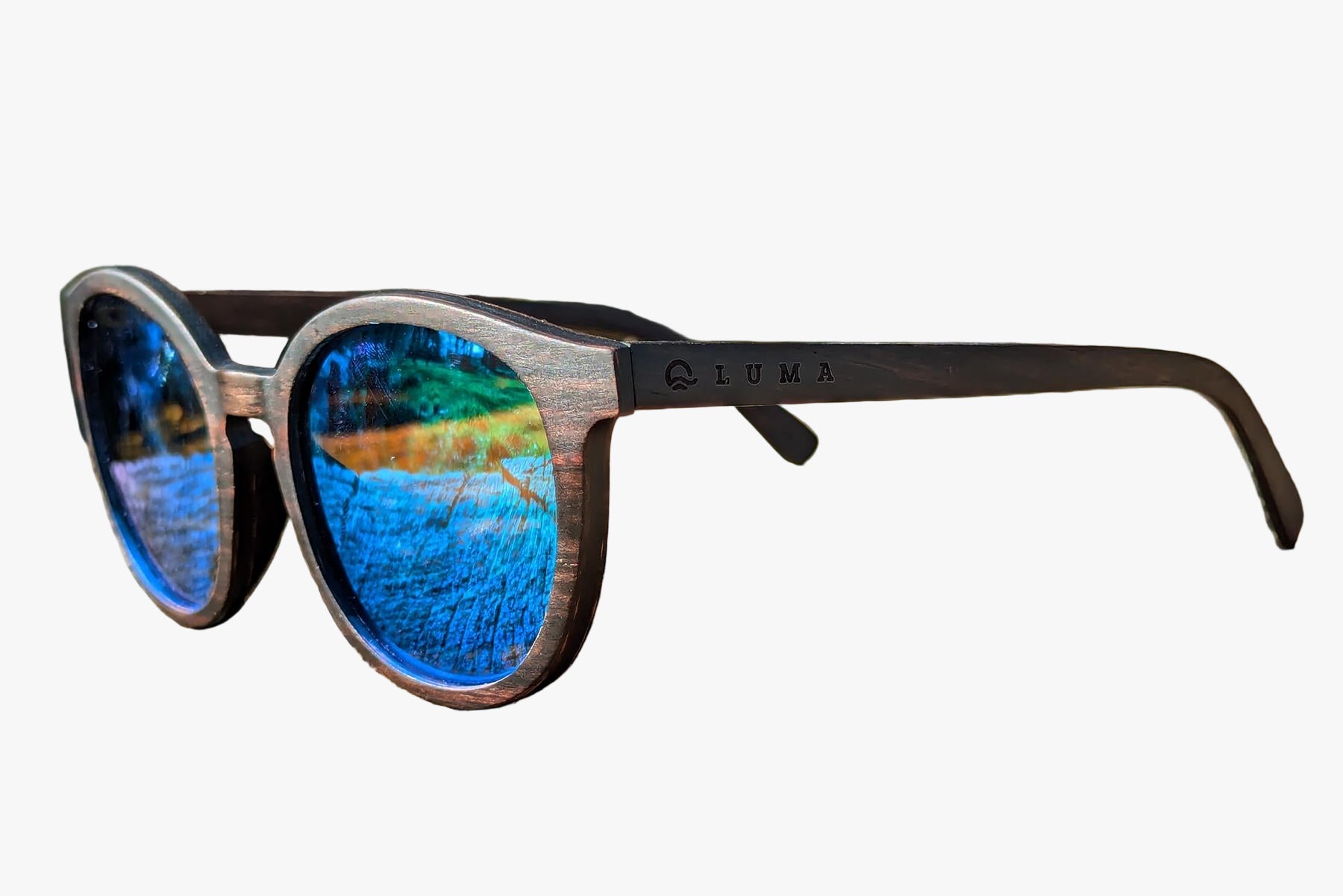 Wooden sunglasses with blue reflective lenses on a textured surface