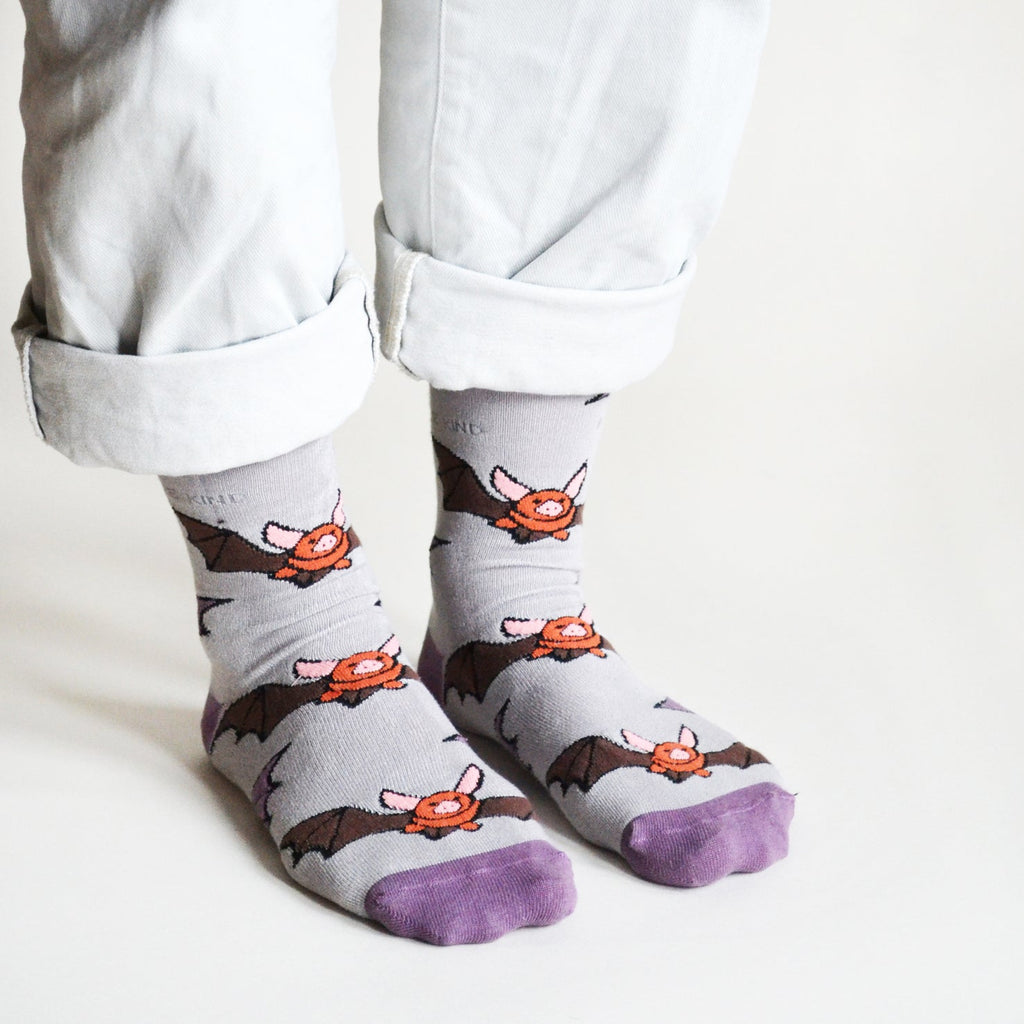Person wearing socks with bat designs on a light background