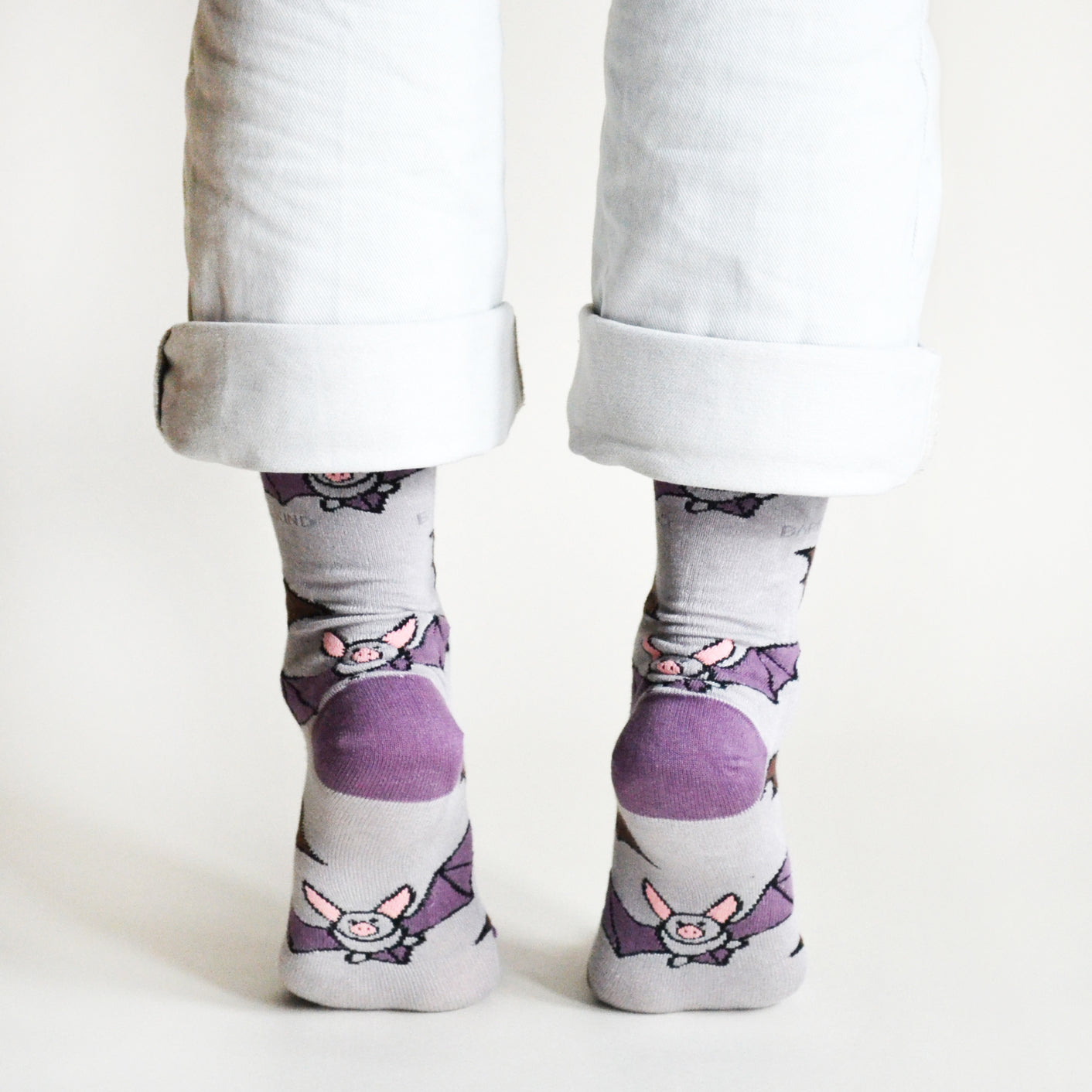 Person wearing socks with bat designs on a light background