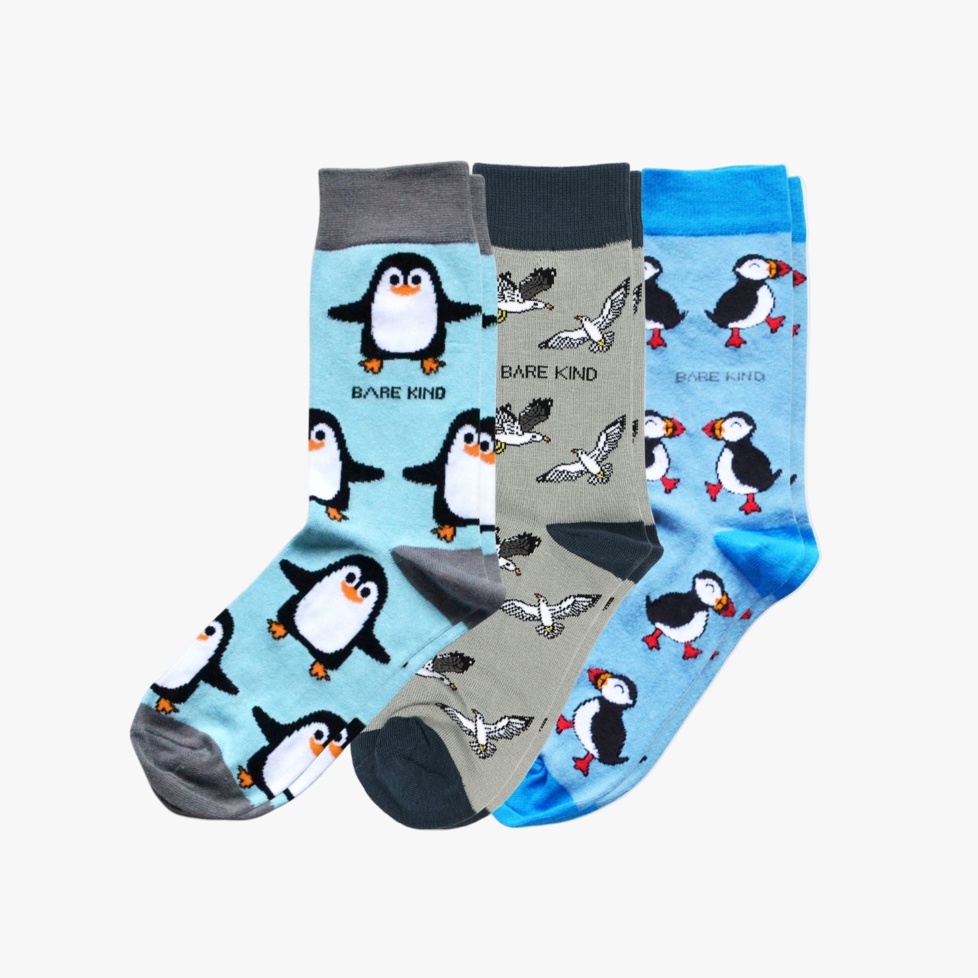 Three pairs of socks with penguin and bird designs on a white background