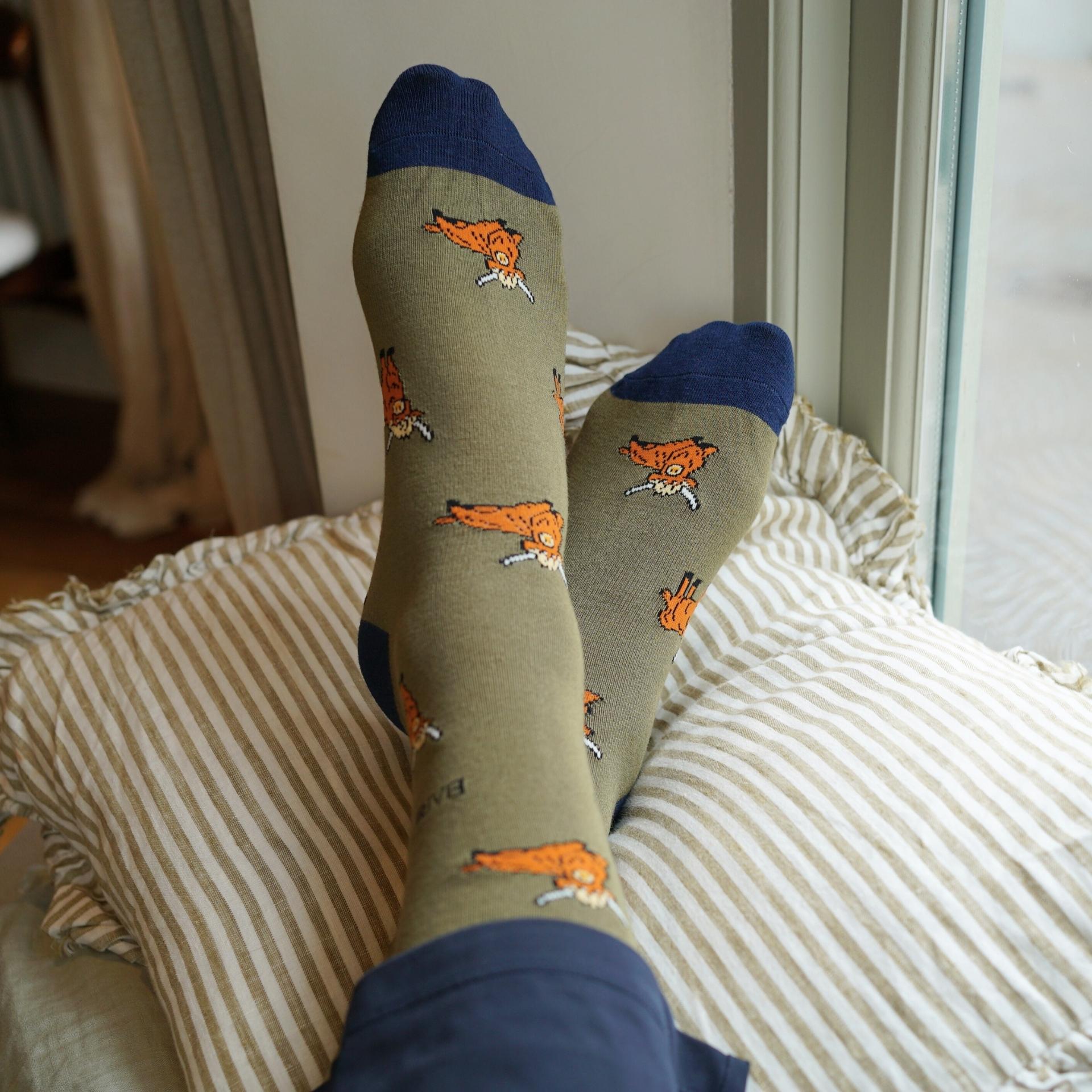 Person wearing socks with fox patterns on a striped pillow